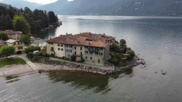 Vista aérea hermoso panorama de la costa del lago de Como, antiguo pequeño pueblo, Lierna, Lombardía, Italia  - Metraje, vídeo