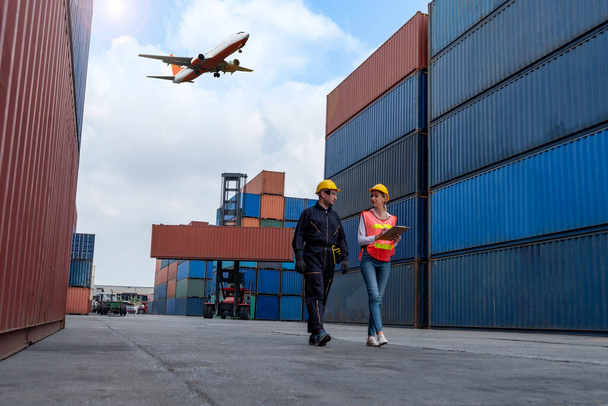 Trabajador industrial trabaja con su compañero de trabajo en el puerto de contenedores de envío en el extranjero - Foto, imagen