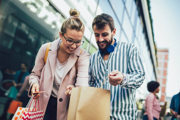 Jeune couple heureux après le shopping tenant une carte de crédit - Photo, image