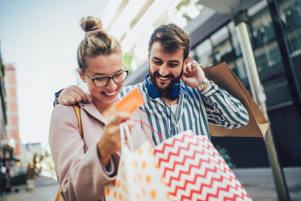Giovane coppia felice dopo lo shopping in possesso di una carta di credito - Foto, immagini