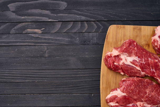 meat steak food cooking dark wood background - Фото, изображение