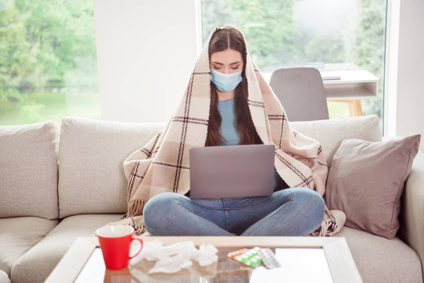 Full size photo of young woman wear mask cover plaid work laptop distance coronavirus pandemic sick indoors - 写真・画像