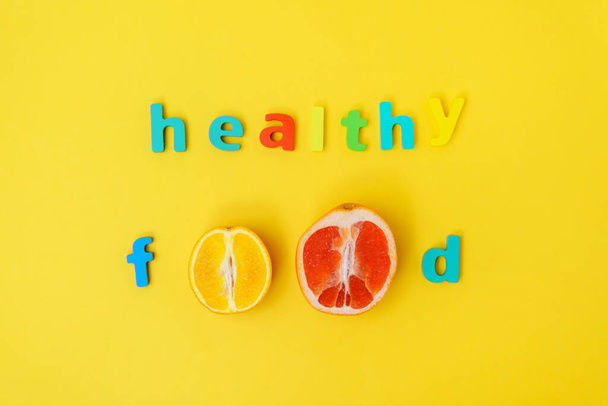 Inscripción comida saludable en un fondo amarillo vista superior. - Foto, Imagen