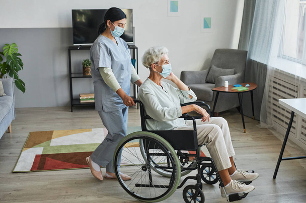 Pflegekraft hilft Senioren im Rollstuhl - Foto, Bild