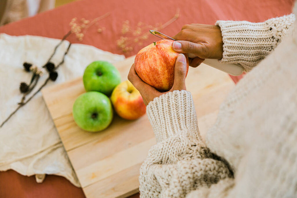 Frauenhände beim Schälen eines Apfels - Foto, Bild