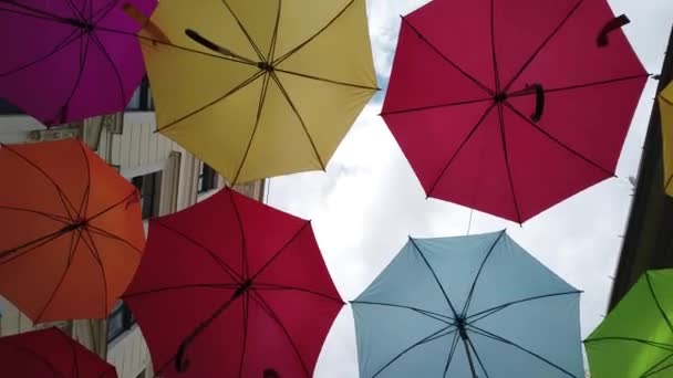 Farbige Regenschirme hängen über der Straße - Filmmaterial, Video