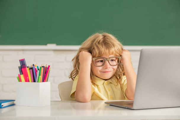 オンライン教育の概念です。ノートパソコンを持ったメガネのオタクの子供。9月1日e-learning - 写真・画像