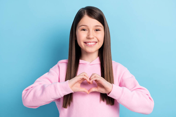 Photo of young school girl happy positive smile show fingers heart symbol love isolated over blue color background - Fotografie, Obrázek