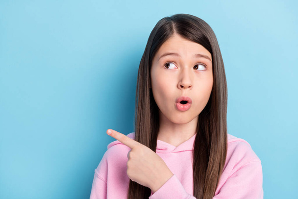 Photo of young preteen girl amazed surprised look point finger empty space ad promo suggest isolated over blue color background - Foto, Bild