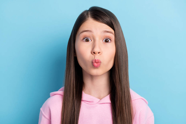 Portrait of funny cute long hair girl blow kiss wear pink sweatshirt isolated on bright blue color background - Photo, Image