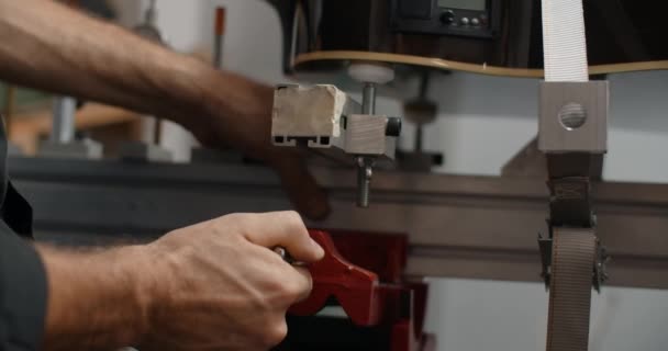 Luthier τοποθετεί την ακουστική κιθάρα στο jig στο κατάστημα επισκευής μουσικών οργάνων, 4k 60p 10 bit - Πλάνα, βίντεο
