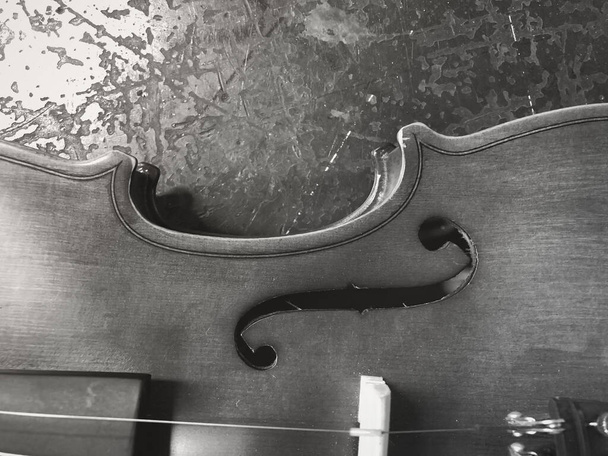Metade do lado frontal do show de violino F-hole detail.put no fundo, luz embaçada ao redor, tom vintage - Foto, Imagem