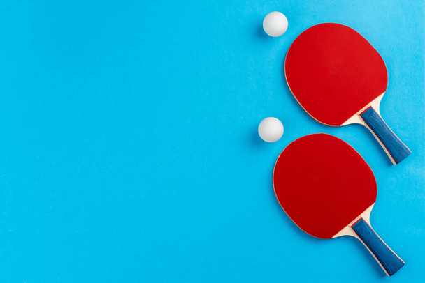 Ping pong racket and ball on blue background - Foto, afbeelding