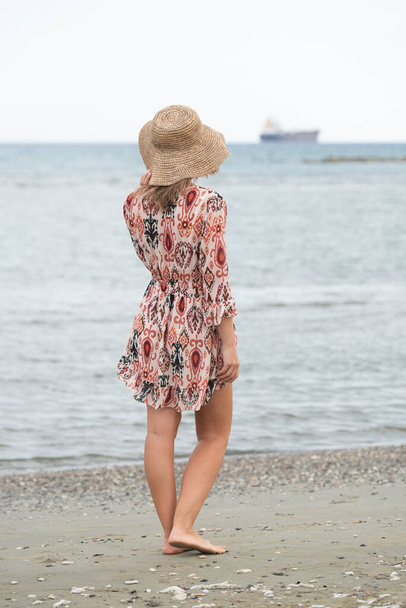 Tyttö etsii kaukaisuuteen, merta vastaan, kesällä mieliala, nainen hattu rannalla - Valokuva, kuva
