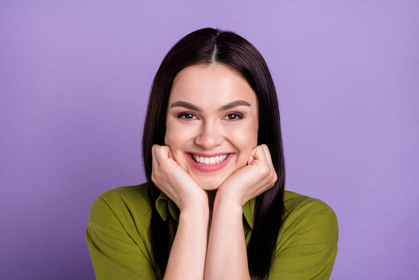 Photo of funny dreamy young woman wear khaki outfit arms cheeks smiling isolated violet color background - Foto, afbeelding