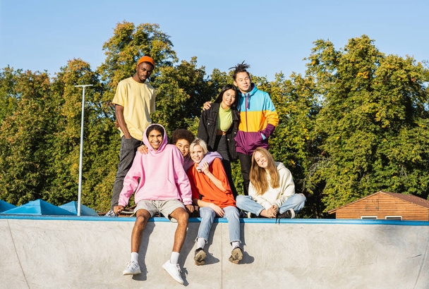 Multicultural group of young friends bonding outdoors and having fun - Stylish cool teens gathering at urban skate park - Fotoğraf, Görsel