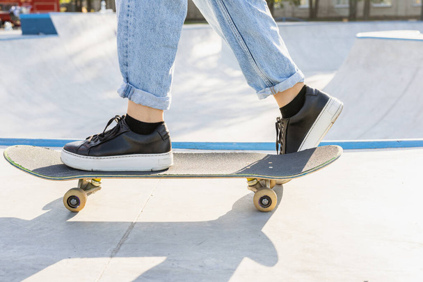 Stylish cool teen female skateboarder at skate park, close-up on shoes - Φωτογραφία, εικόνα