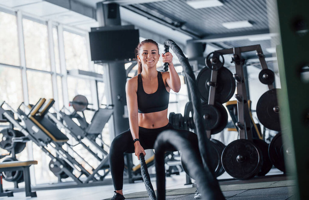 Young girl in sportive clothes is in the gym at daytime. - Fotoğraf, Görsel
