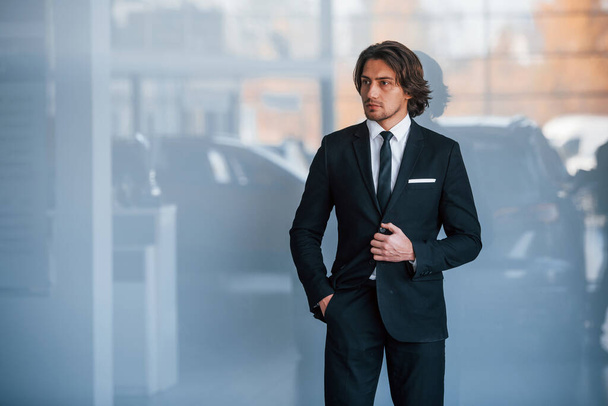 Portrait of handsome young businessman in black suit and tie. - Fotó, kép