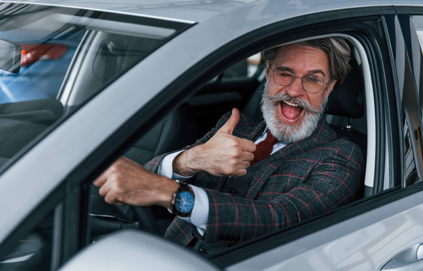 Happy stylish senior man with grey hair and mustache showing thumb up. - Foto, Imagem