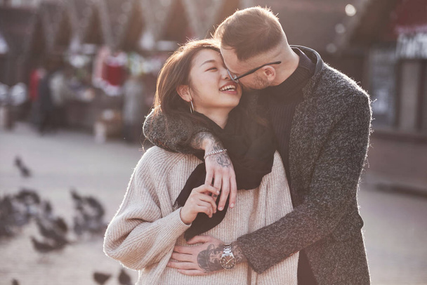 Asian girl with her caucasian boyfriend have fun outdoors in the city. - Zdjęcie, obraz