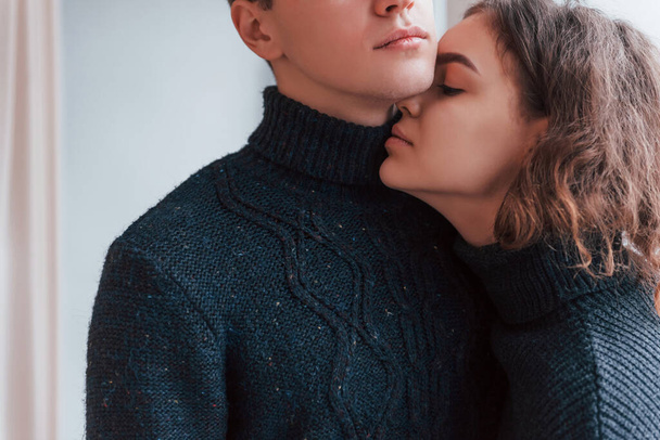 Cute young couple embracing each other indoors in the studio. - 写真・画像