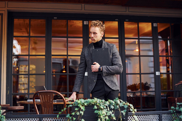 Man in elegant formal wear outside against modern building. - Foto, imagen
