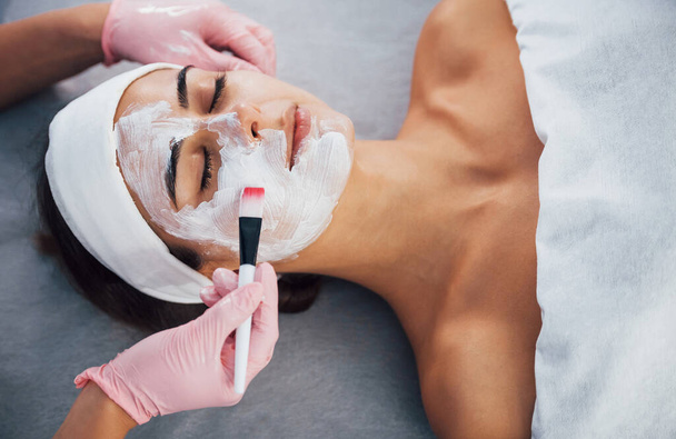 Close up view of woman that lying down in spa salon and have face cleaning procedure by the mask. - 写真・画像