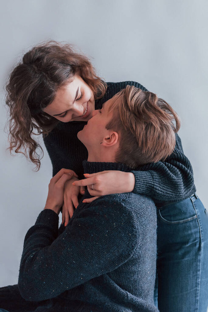Cute young couple embracing each other indoors in the studio. - Fotografie, Obrázek