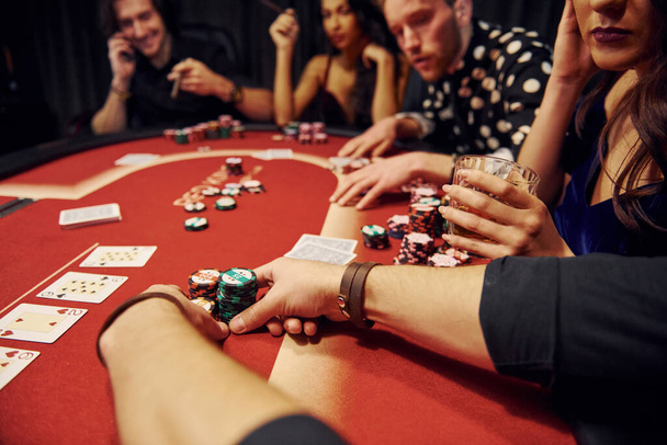 Group of elegant young people that playing poker in casino together. - Photo, image