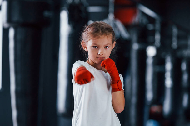 Portrait of young little girl in sportive wear that is in the gym have exercise day. Conception of boxing. - Φωτογραφία, εικόνα