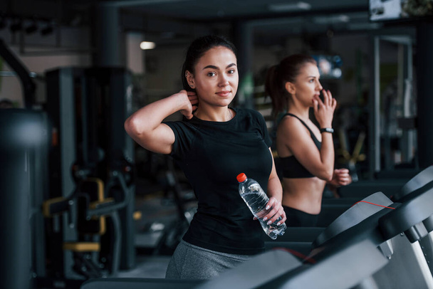 Two young girls in sportive clothes is in the gym together at treadmill. - Fotografie, Obrázek