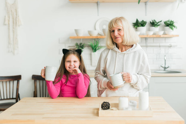 Grandmother and granddaughter having fun together at home. Generation and family concept - Фото, зображення