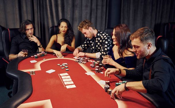 Top view of elegant young people that playing poker in casino. - Фото, изображение