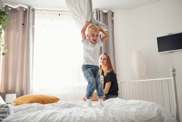 Mother playing and have fun with her son in bedroom at daytime. - Foto, immagini