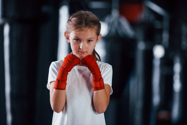 Portrait of young little girl in sportive wear that is in the gym have exercise day. Conception of boxing. - Фото, зображення