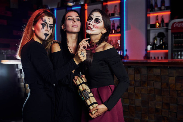 Three female friends is on the thematic halloween party in scary makeup and costumes. - Fotoğraf, Görsel