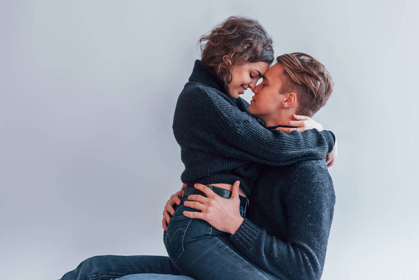 Cute young couple embracing each other indoors in the studio. - Foto, afbeelding