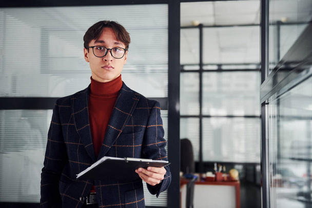 Office worker in glasses and in formal clothes standing indoors. - Fotó, kép