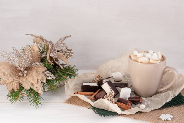クリスマスの構図、白い背景のマシュマロとココア、クリスマスツリーの枝、お菓子、コピースペース - 写真・画像