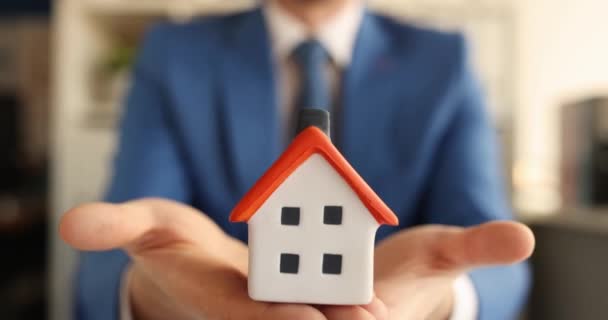 Чоловік в костюмі і краватка тримає іграшковий будинок в руках 4k фільм
 - Кадри, відео