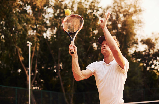 Game in action. Young tennis player in sportive clothes is on the court outdoors. - Foto, imagen
