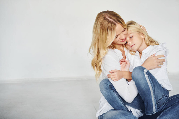 Mother with her daughter have fun together in the studio with white background. - 写真・画像