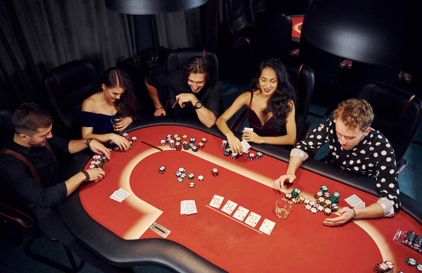 Top view of elegant young people that playing poker in casino. - Fotó, kép