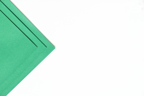 Auf einem weißen Hintergrund mit weichem Schatten und Kopierraum ist dunkelgrünes Papier in geometrischen Formen geschichtet., abstraktes Hintergrundkonzept. - Foto, Bild