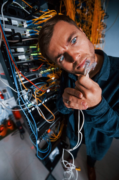 Close up view of funny man with internet wires in server room. - Photo, Image