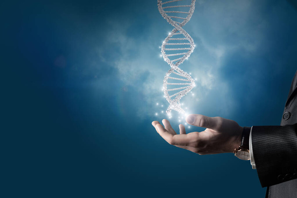 Деловой человек показывает молекулу ДНК человека на синем фоне. - Фото, изображение