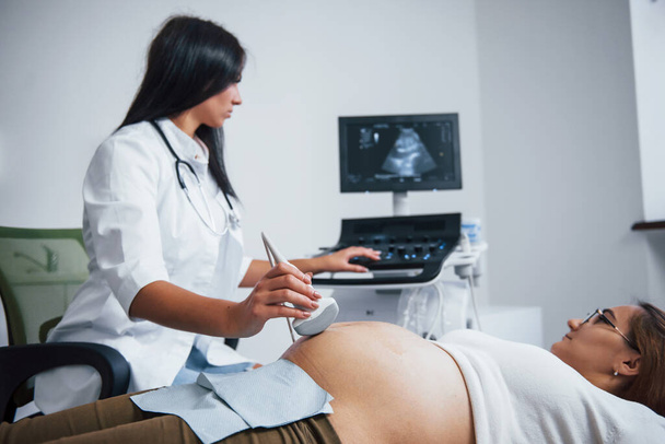 A női orvos ultrahangot csinál egy terhes nőnek a kórházban.. - Fotó, kép