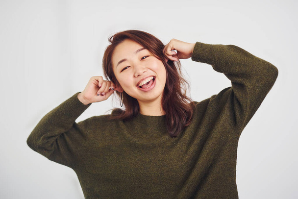 Portrait of happy asian young girl that standing indoors in the studio against white background. - Fotografie, Obrázek