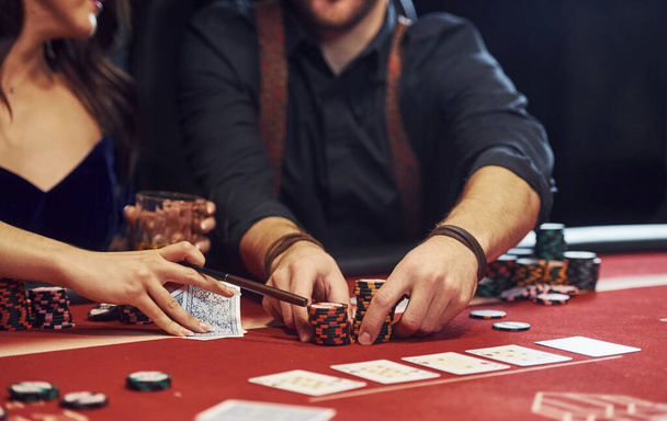 Close up view of elegant young people's hands that playing poker in casino. - Fotografie, Obrázek